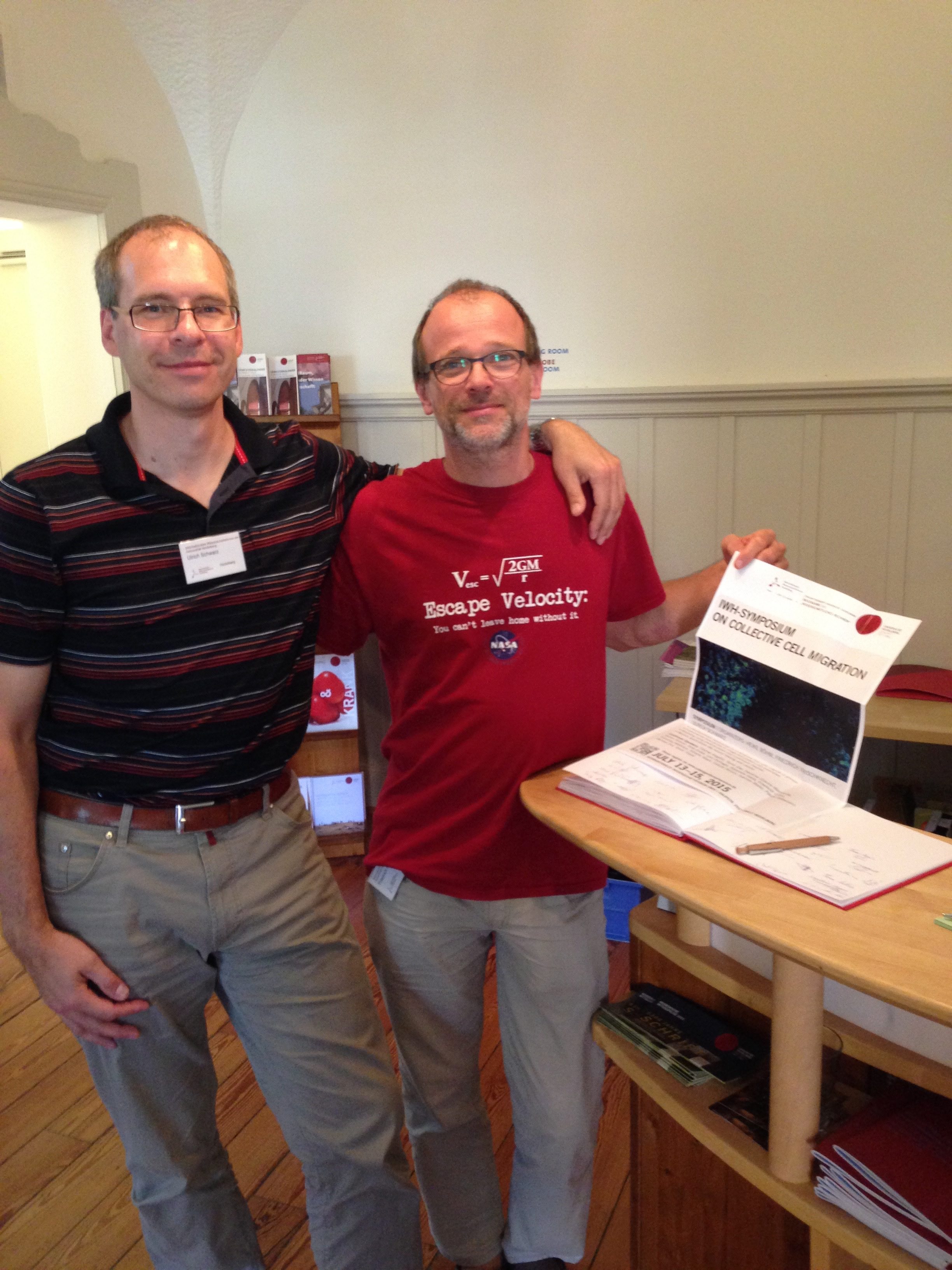 Ulrich Schwarz (left) and Friedrich Frischknecht (right) as organizers at the 2015 Symposium on Collective Cell Migration at Heidelberg. True to their interdisciplinary approach, the biologist wears a physics T-shirt.