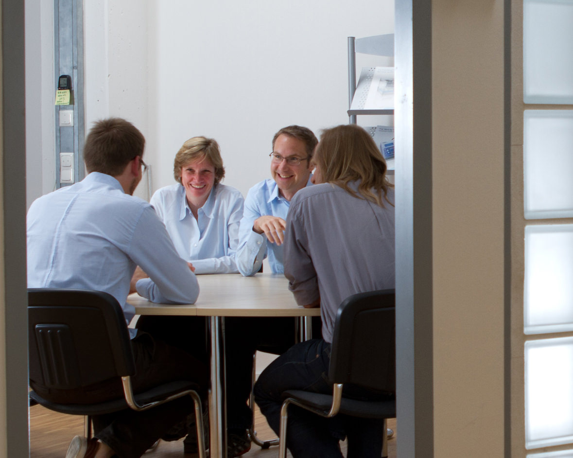 Brüggemann in the conference room with colleagues Niels Fertig, Michael George, and Matthias Beckler.