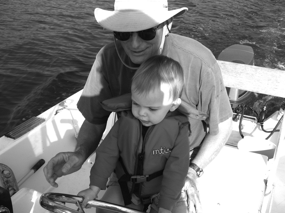 Moore teaching his grandson how to drive a boat.